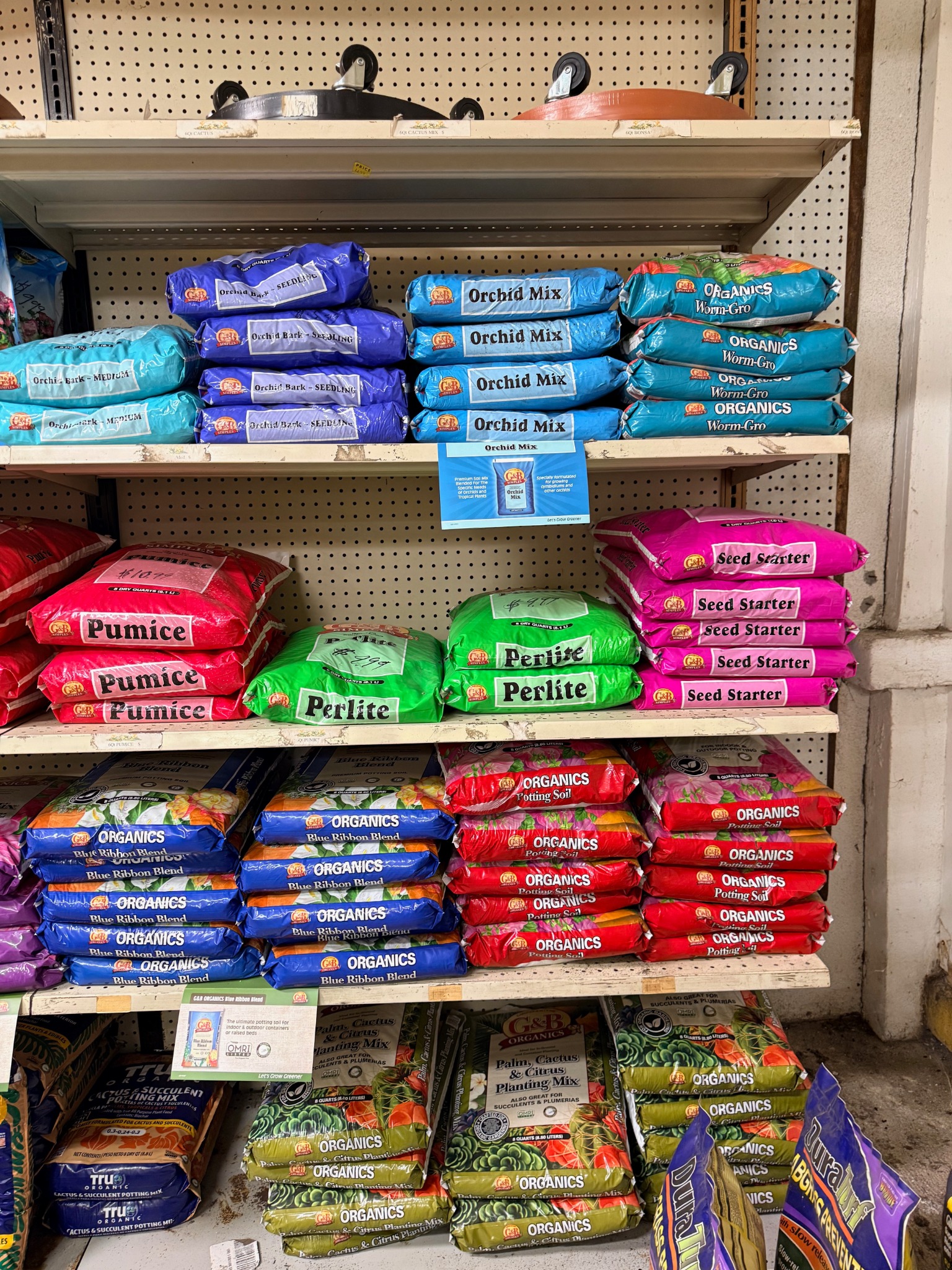 Shelf of G and B Organics planting mixes, orchid mix, seed starter, and related soil products